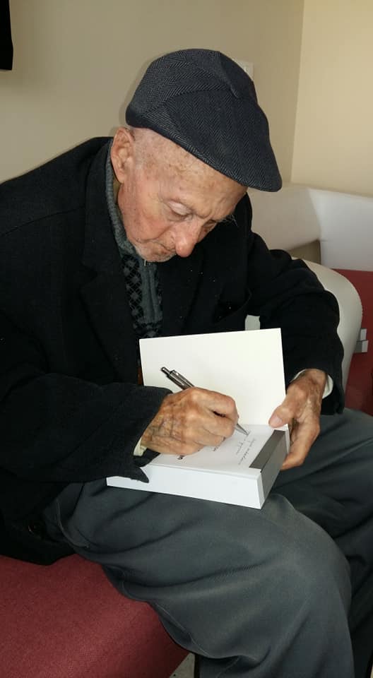 7-Osman Akkuşak kitabını fakire imzalarken